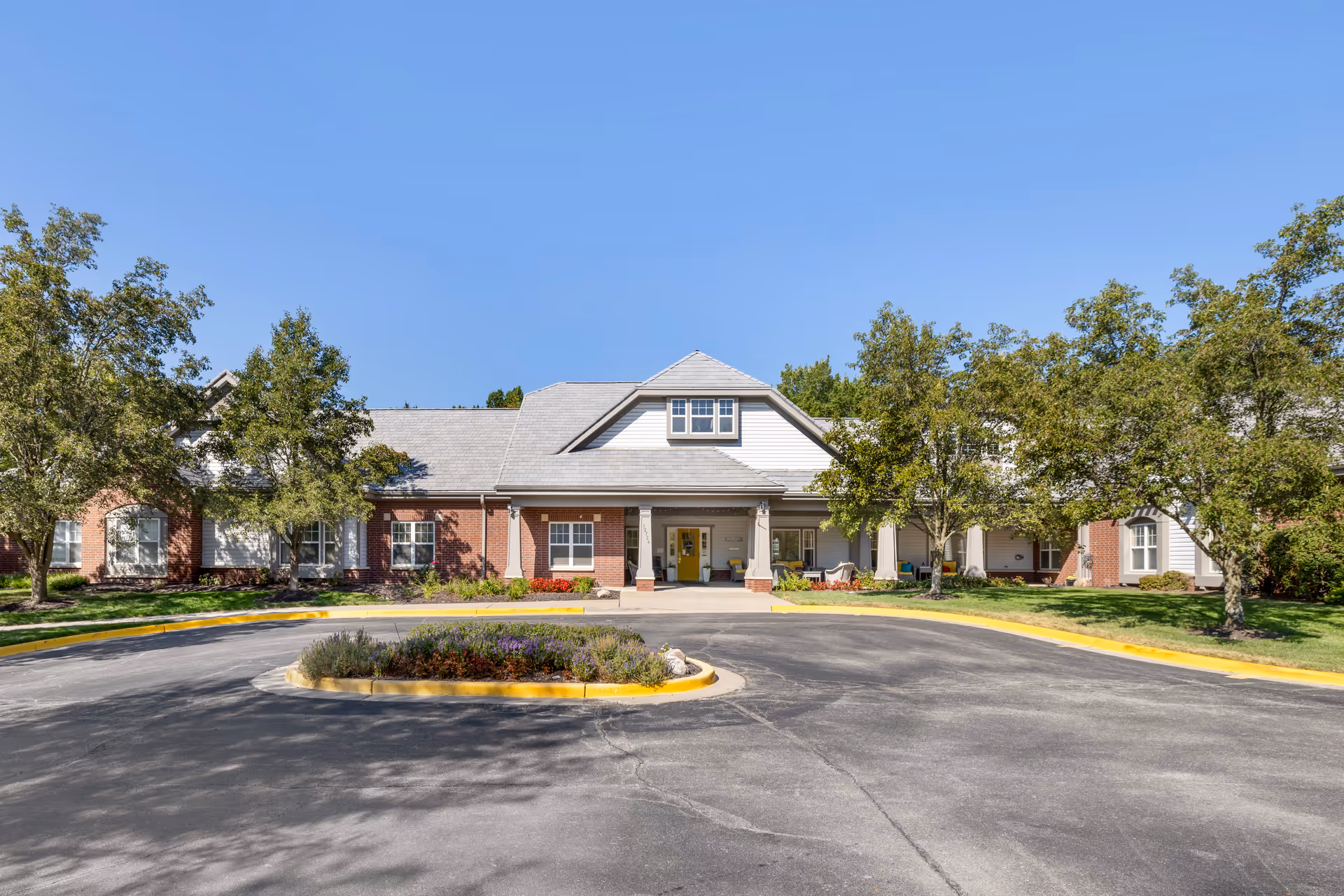 A single-story senior living facility with circular driveway and manicured landscaping.