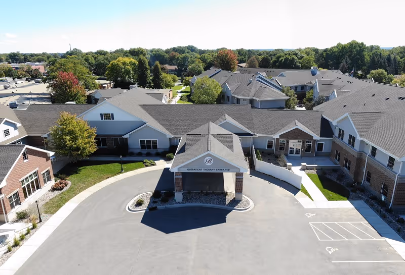 Aerial view of Rennes Health & Rehab Center De Pere with entrance and surrounding parking.