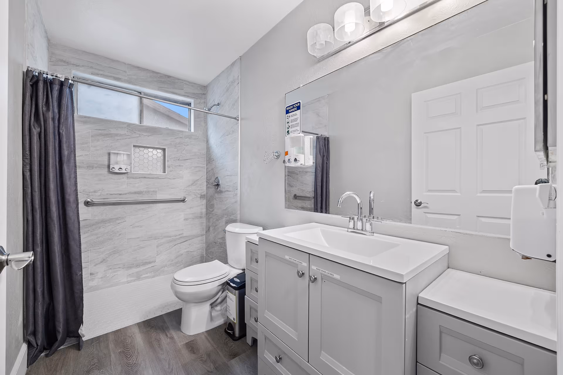 Modern accessible bathroom with walk-in shower, toilet, and vanity.