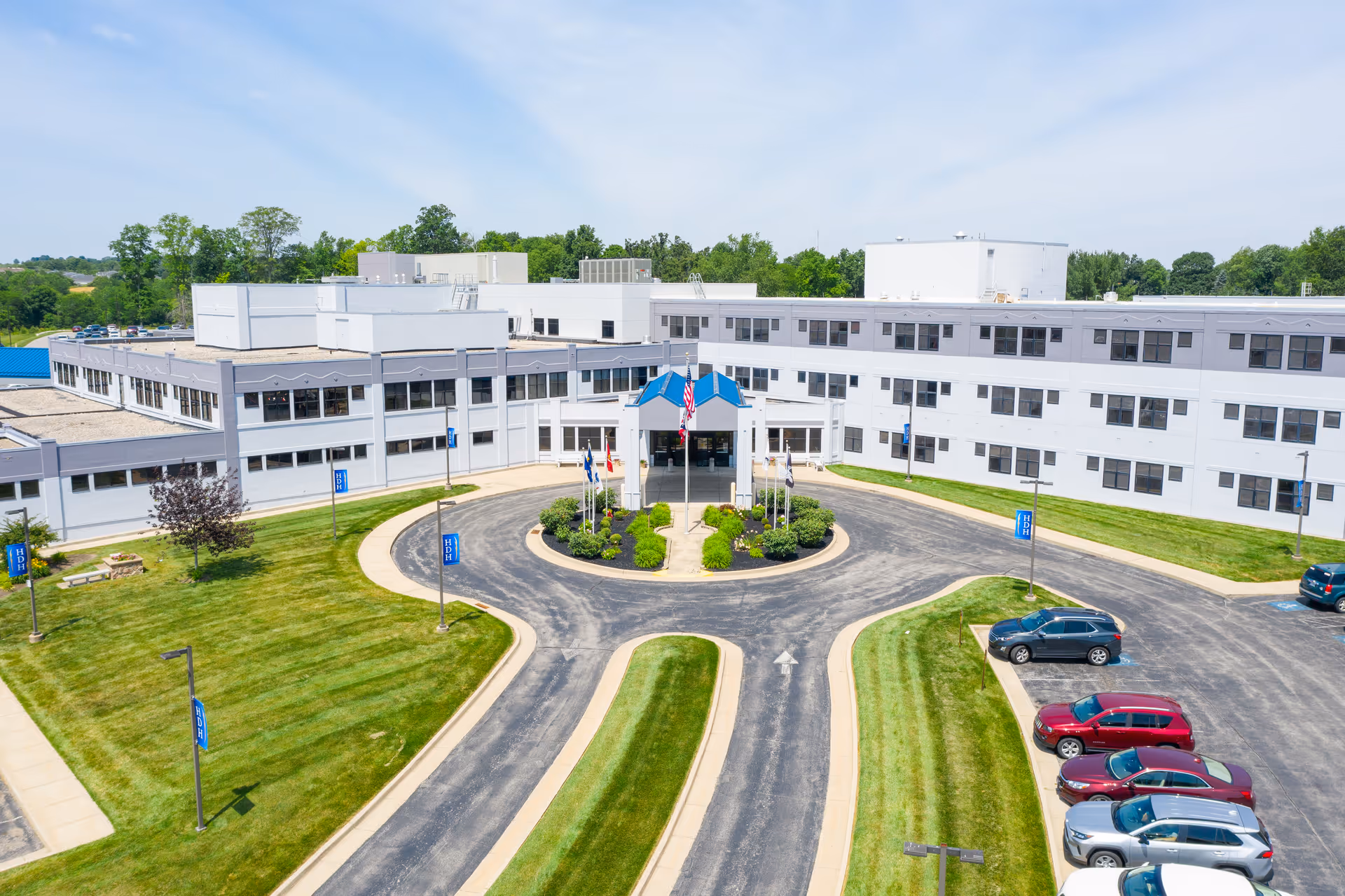 Aerial view of Highland District Hospital with circular driveway and parked cars.