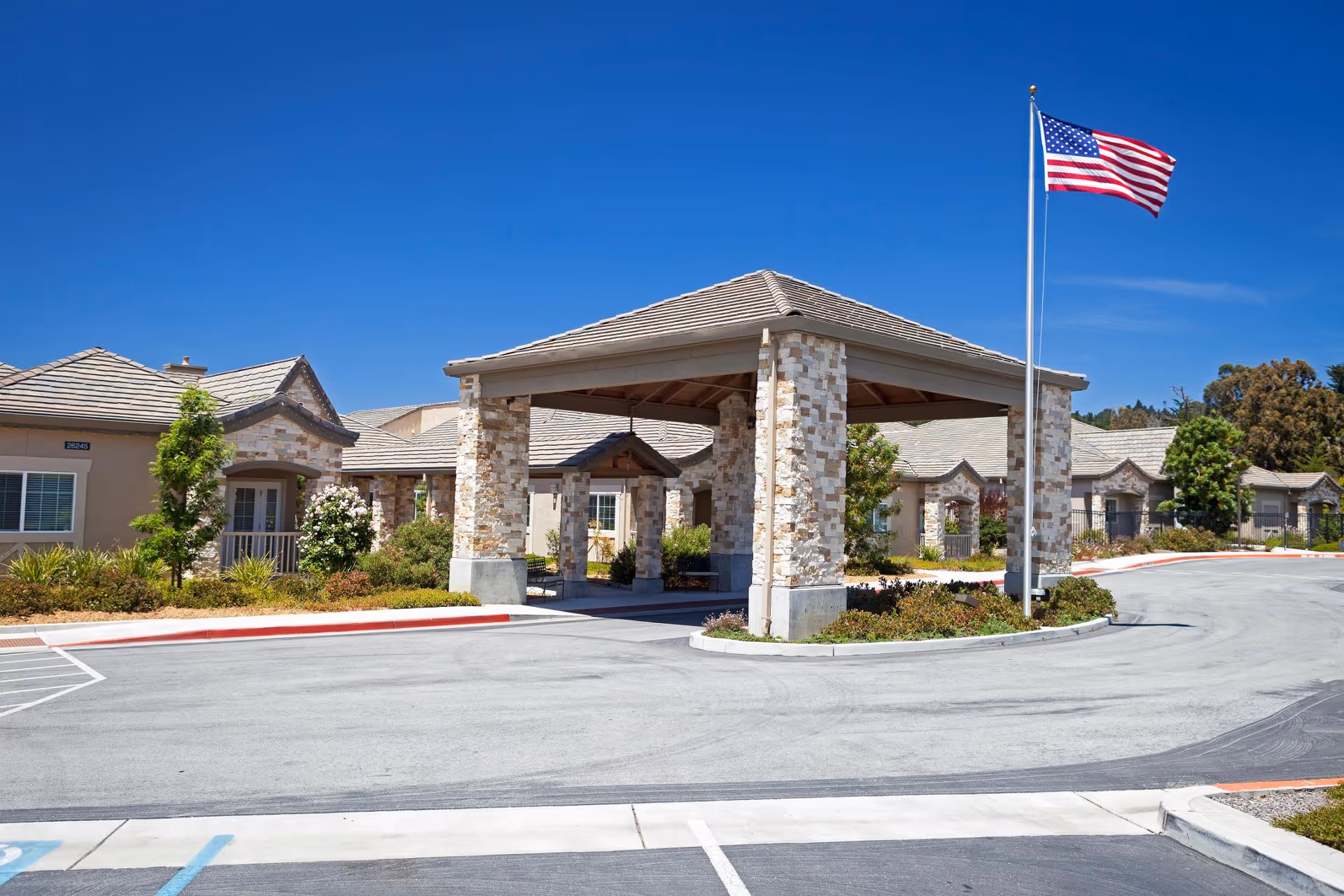 Exterior view of The Cottages of Carmel entrance with stone pillars and flag