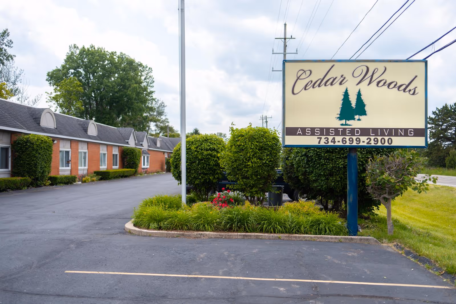 Cedar Woods Assisted Living sign with brick building and landscaped entrance