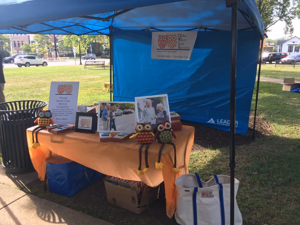 Outdoor booth for Older Wiser Life Services LLC with materials.