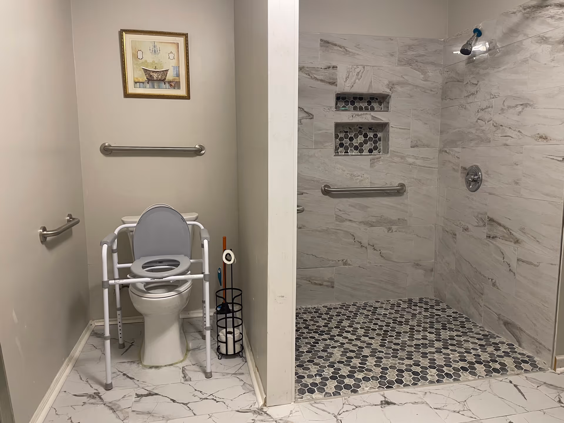 Accessible bathroom with toilet, grab bars, and tiled shower area in a senior living facility.