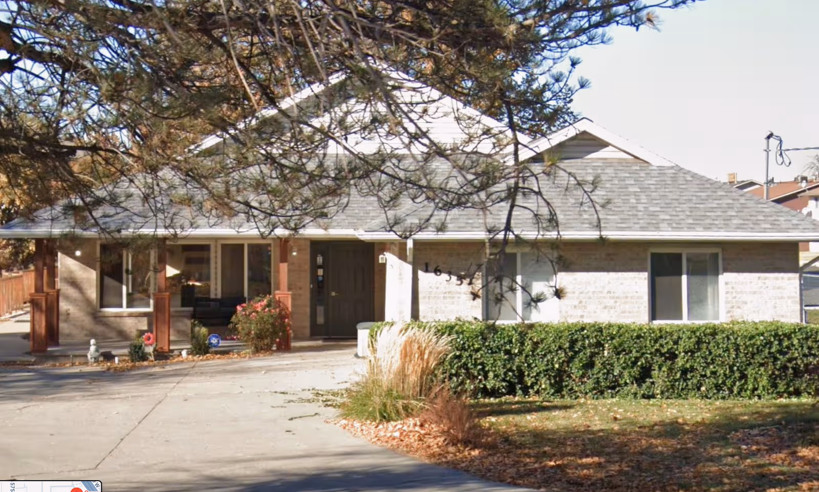 Front exterior of Country Oaks Assisted Living with entry, shrubs, and driveway.