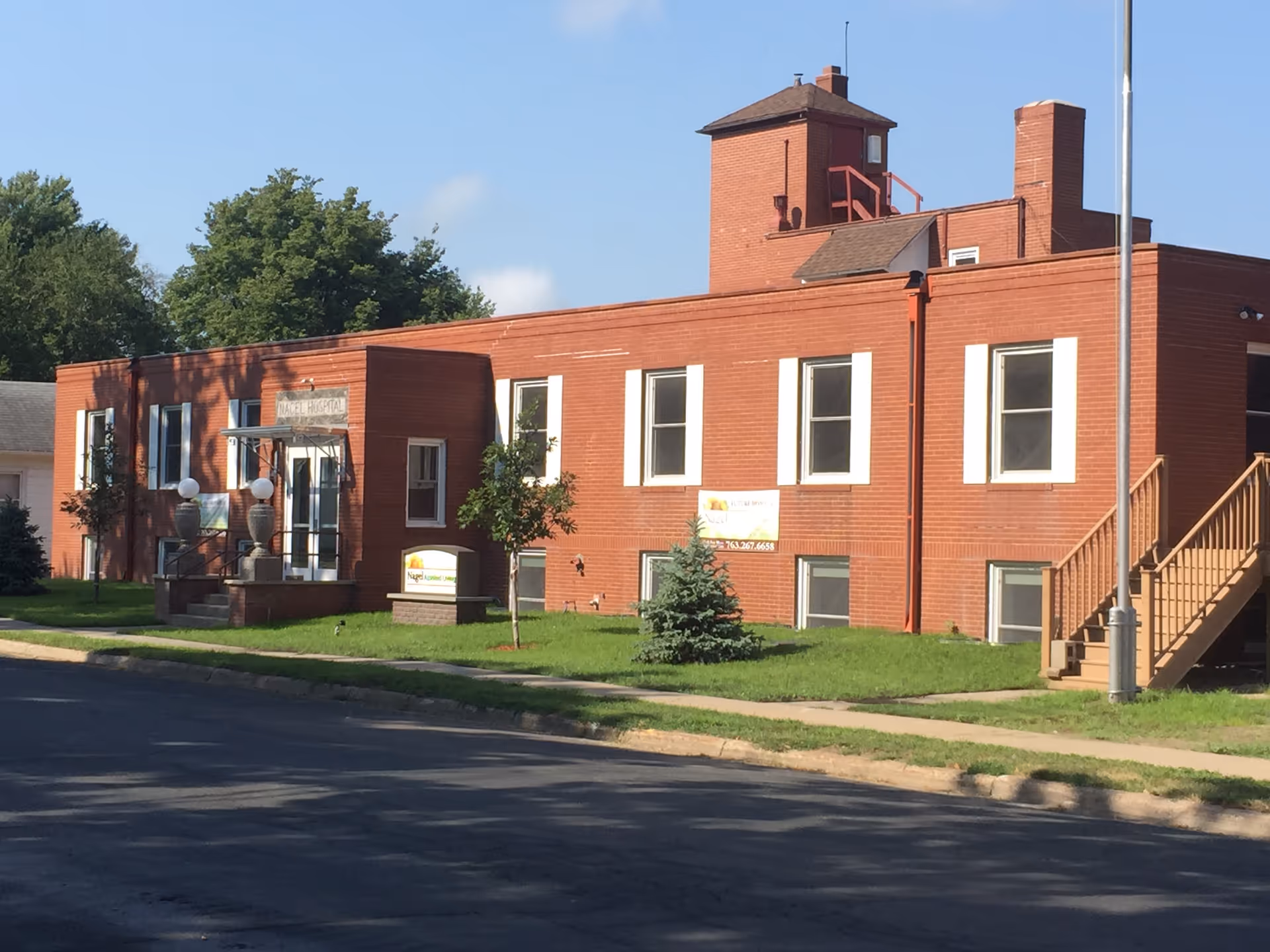 An exterior view shows a red brick Sunflower Communities facility with stairs and a lawn.