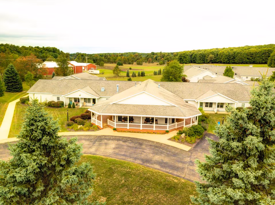 Aerial view of a senior living campus with a central building and surrounding green grounds.