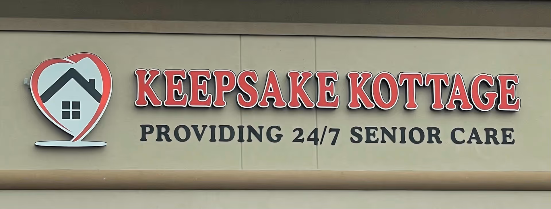 Exterior view of Keepsake Kottage with heart logo and 24/7 Senior Care sign