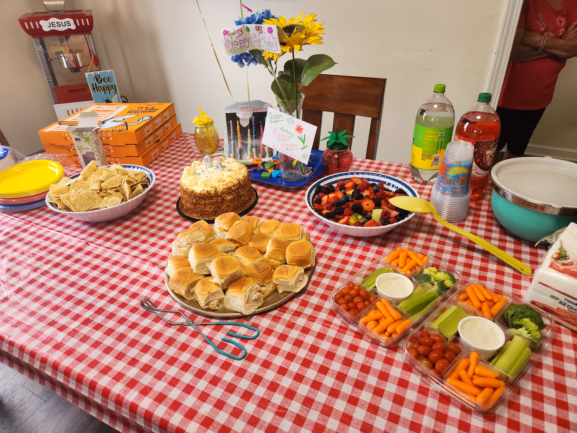 Dining table at Mary's House Family Care Home with cake, fruit, veggies, snacks, and drinks.