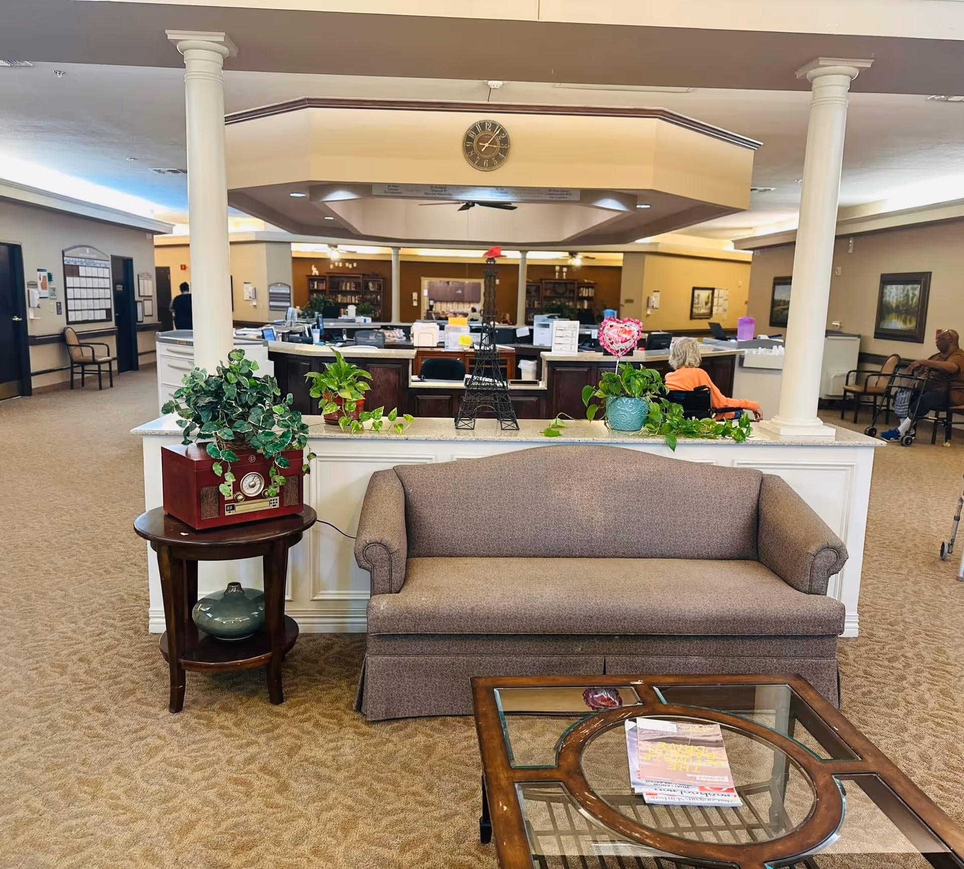 Lobby area of Brentwood Terrace Healthcare and Rehabilitation with sofa, plants, and reception desk.