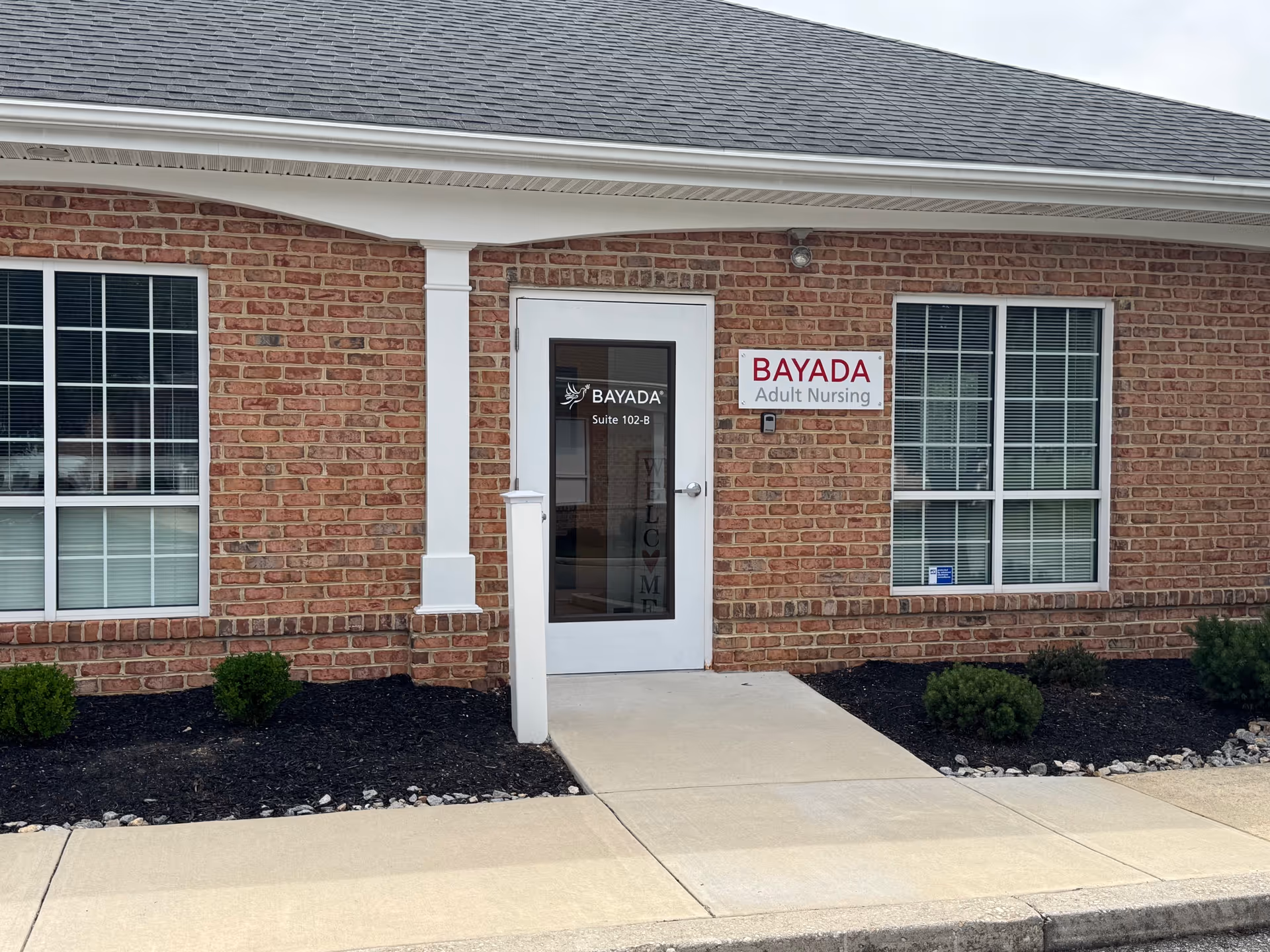 Brick building exterior with BAYADA Adult Nursing sign and glass door entrance