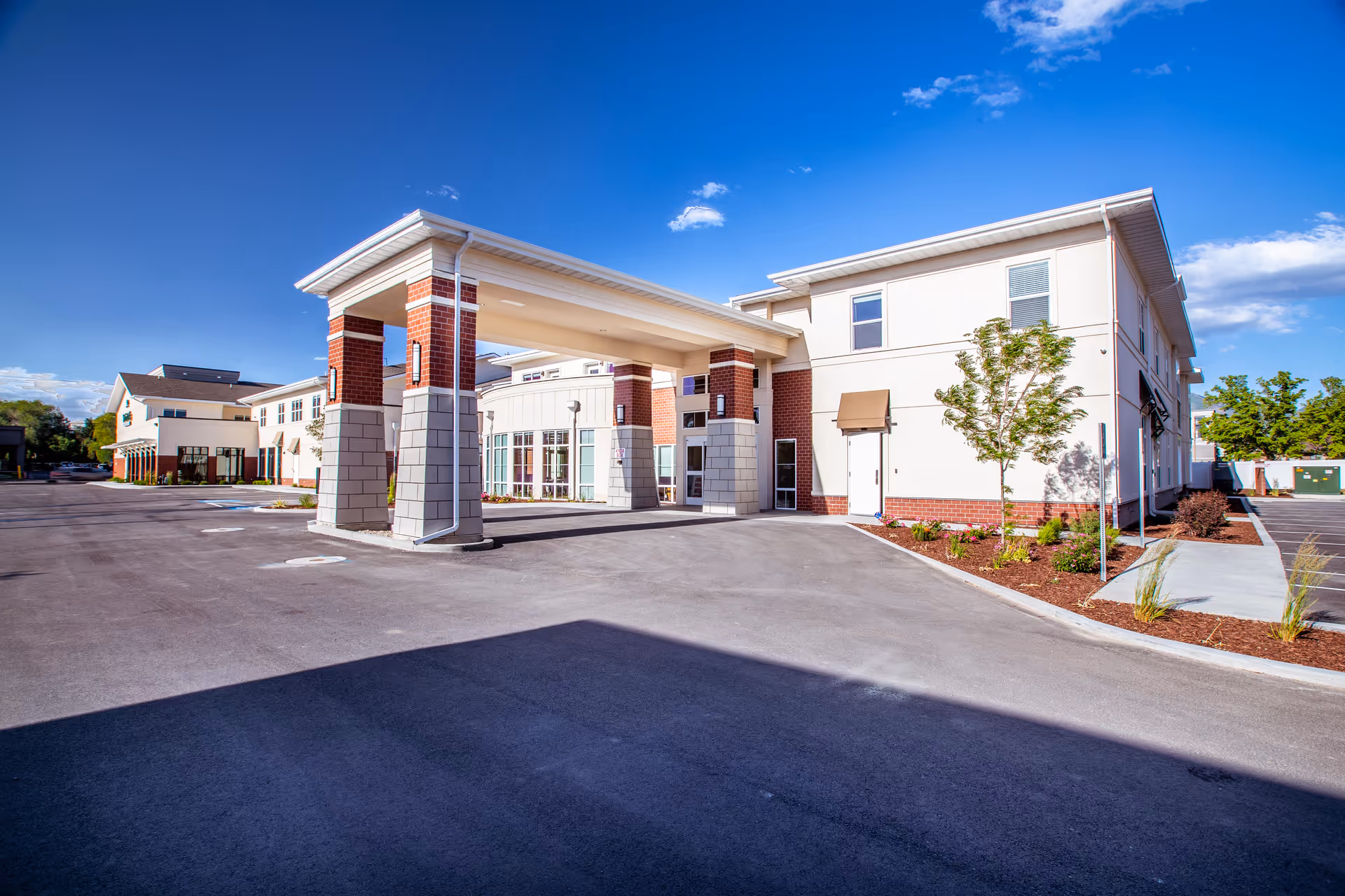 Modern senior living facility exterior with a covered entrance and brick accents