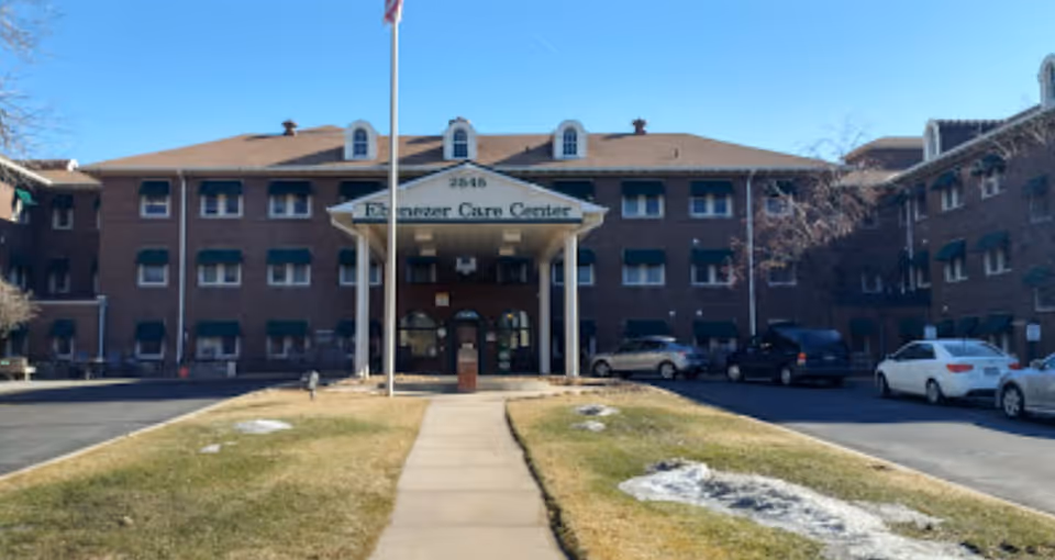Brick senior care facility with sign reading Ebenezer Care Center and a front entrance.