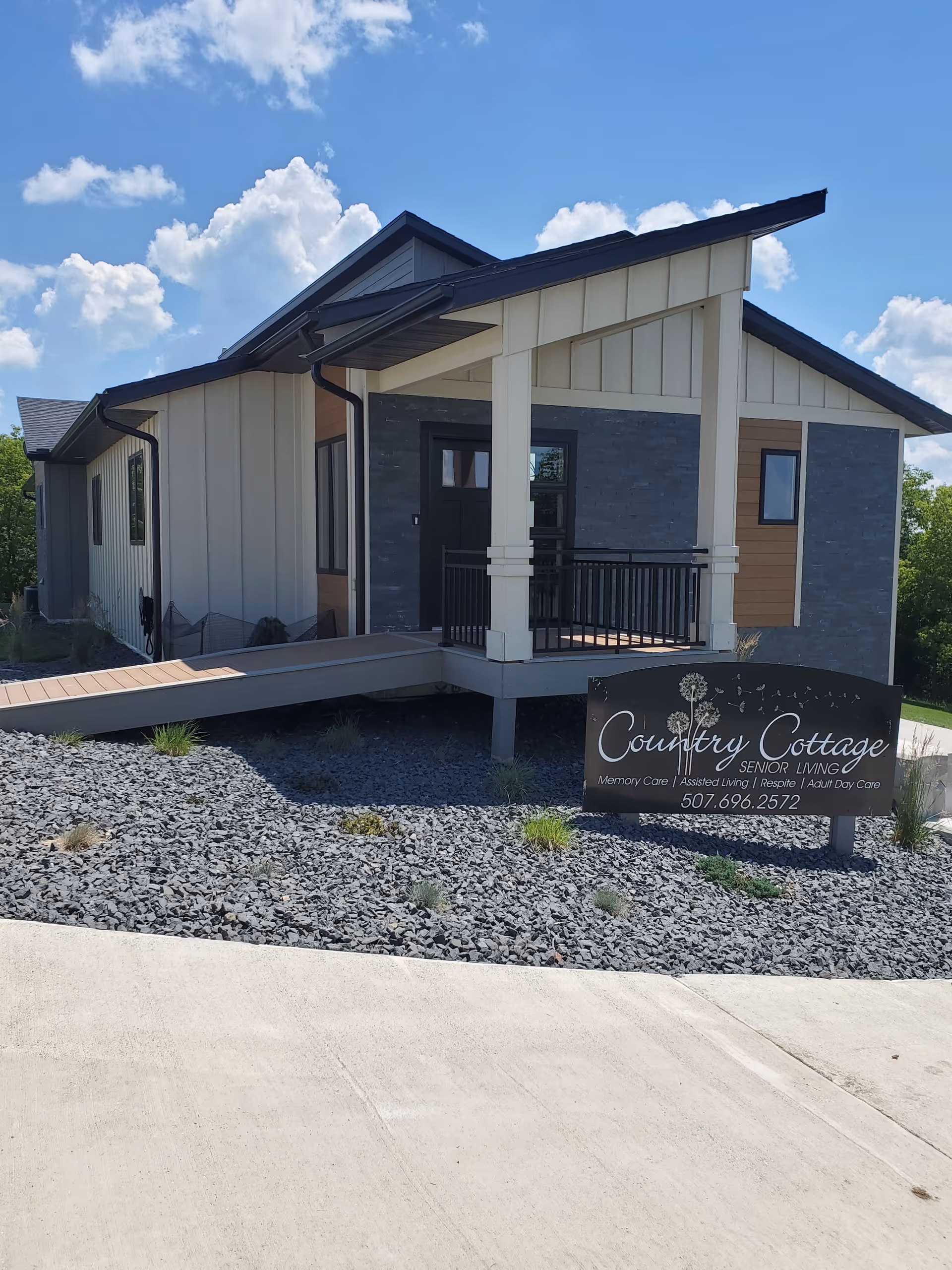 Exterior view of Country Cottage Senior Living building with front porch and sign.
