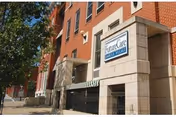 Brick building entrance for Future Care Charles Village with a sign and tree-lined sidewalk.