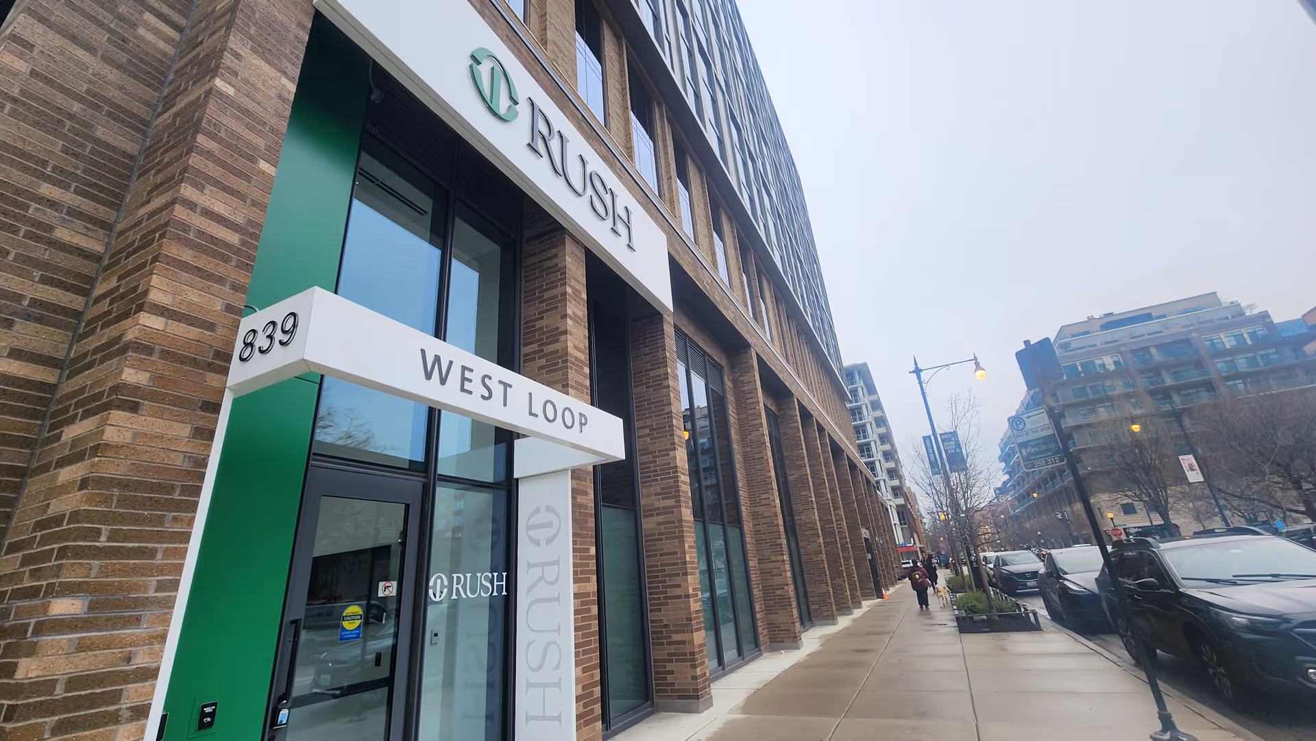Exterior view of Rush West Loop facility along a city sidewalk with signage.