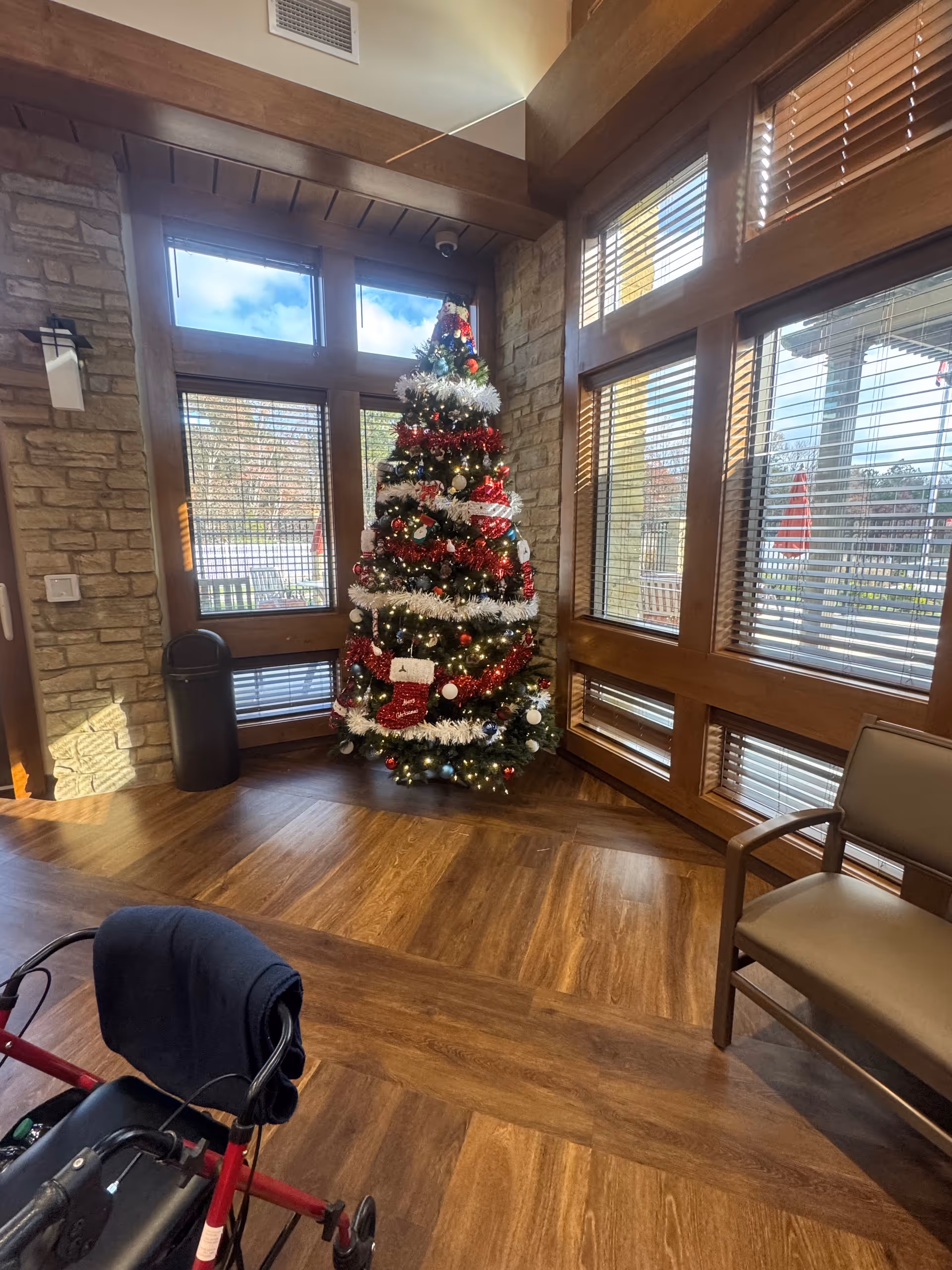 Lodge-style interior lobby of a veterans' home with a decorated Christmas tree.