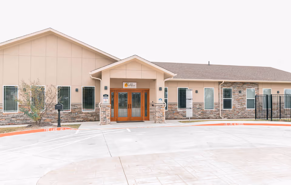 Front view of BeeHive Homes of Rowlett entrance with parking lot.