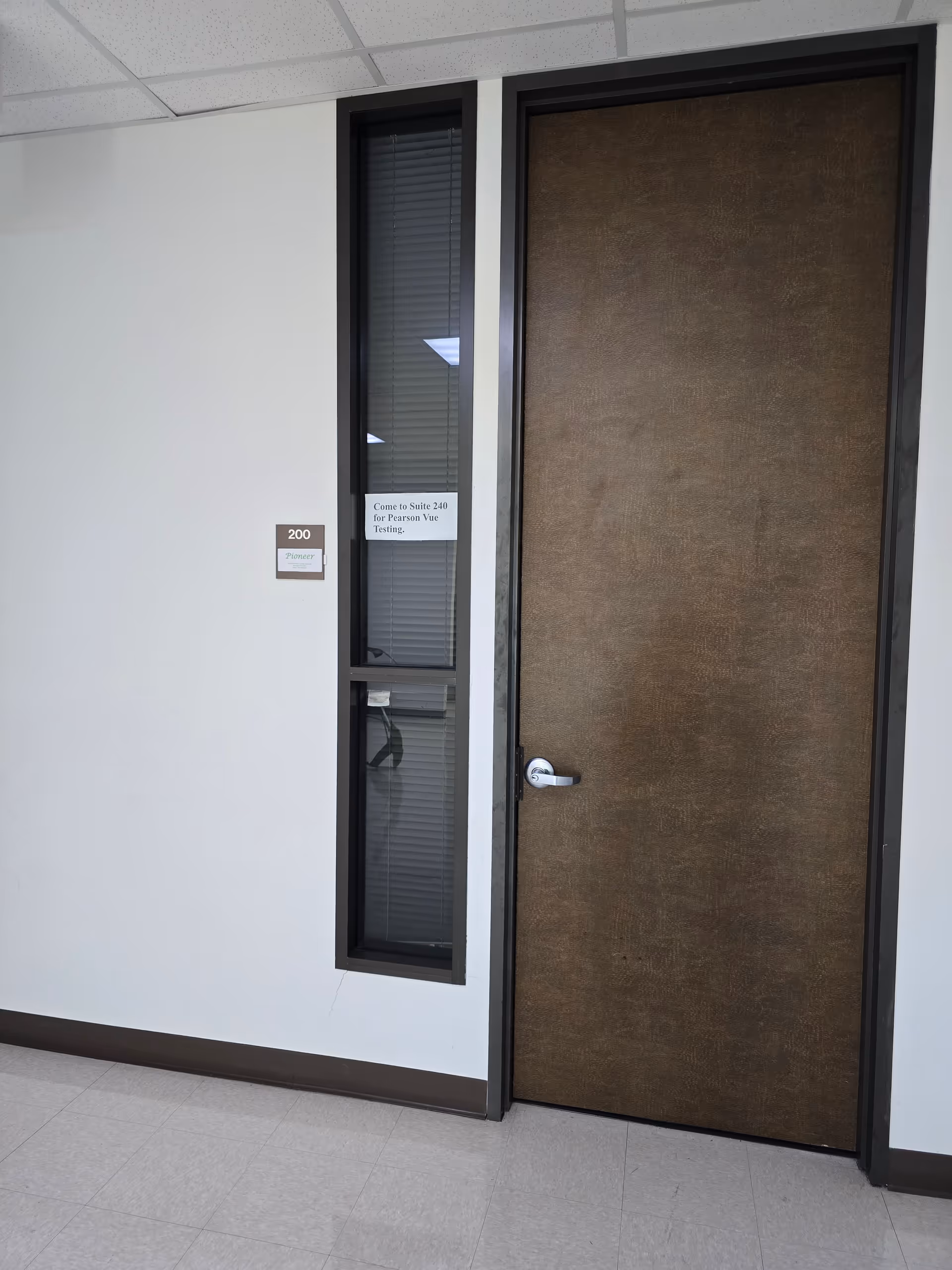Interior hallway with a wooden door and tall window beside room 200.