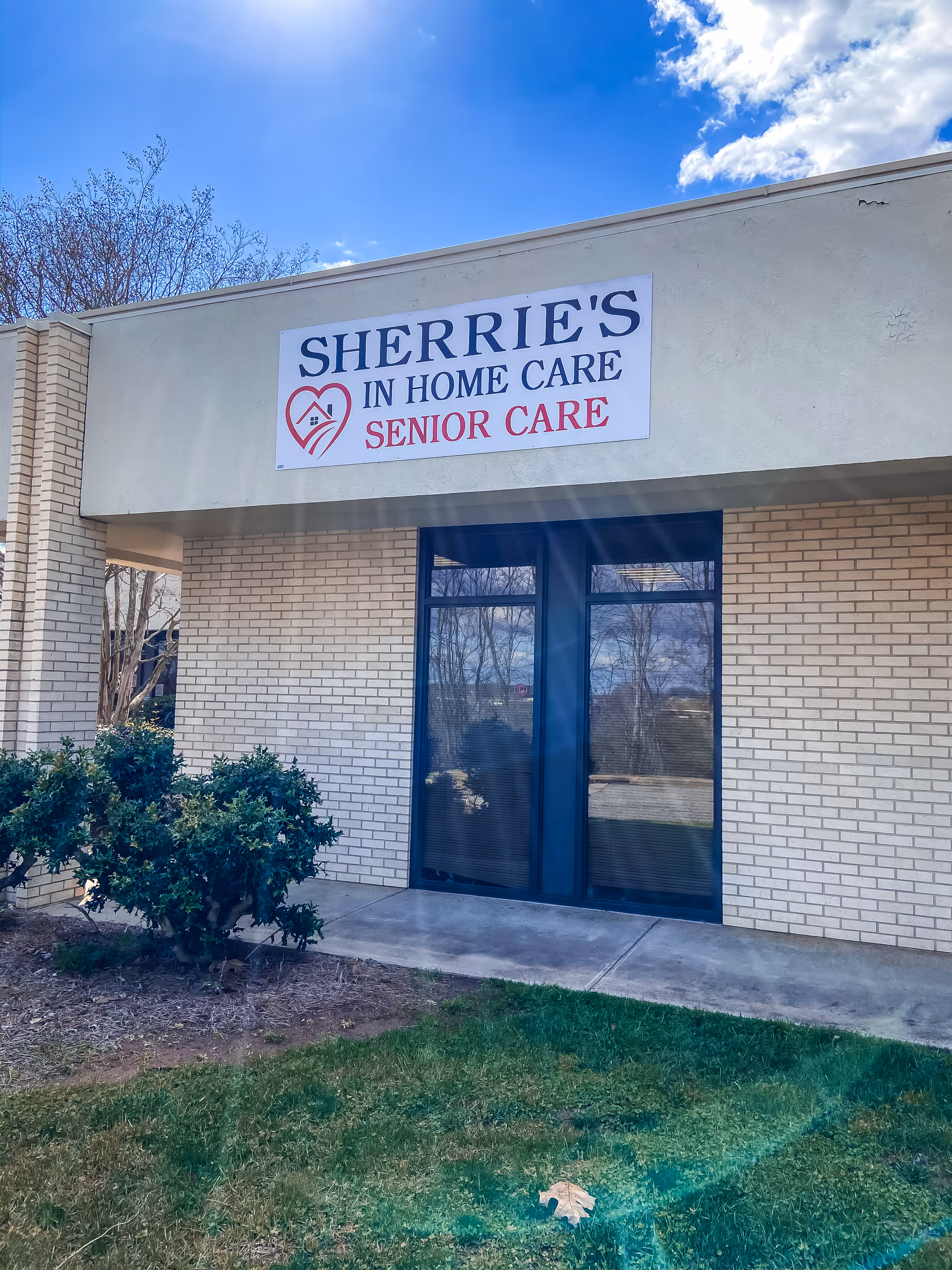 Front exterior of Sherrie's In Home Care Senior Care building with glass doors.