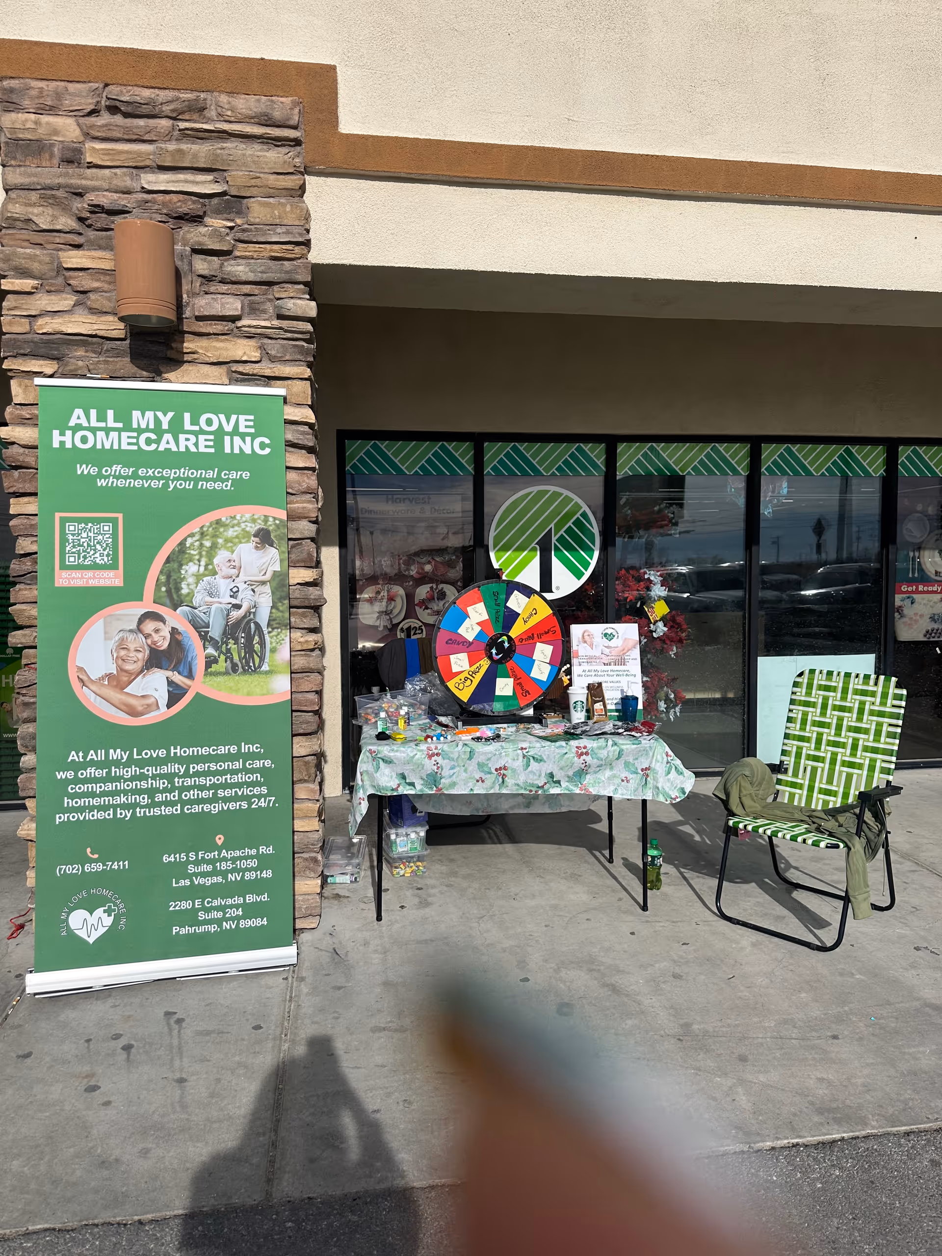 Outdoor storefront setup for All My Love Homecare Inc with a colorful spinning wheel.