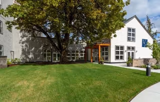Exterior view of Vineyard Park of Covington featuring a white building, green lawn, and entrance canopy.