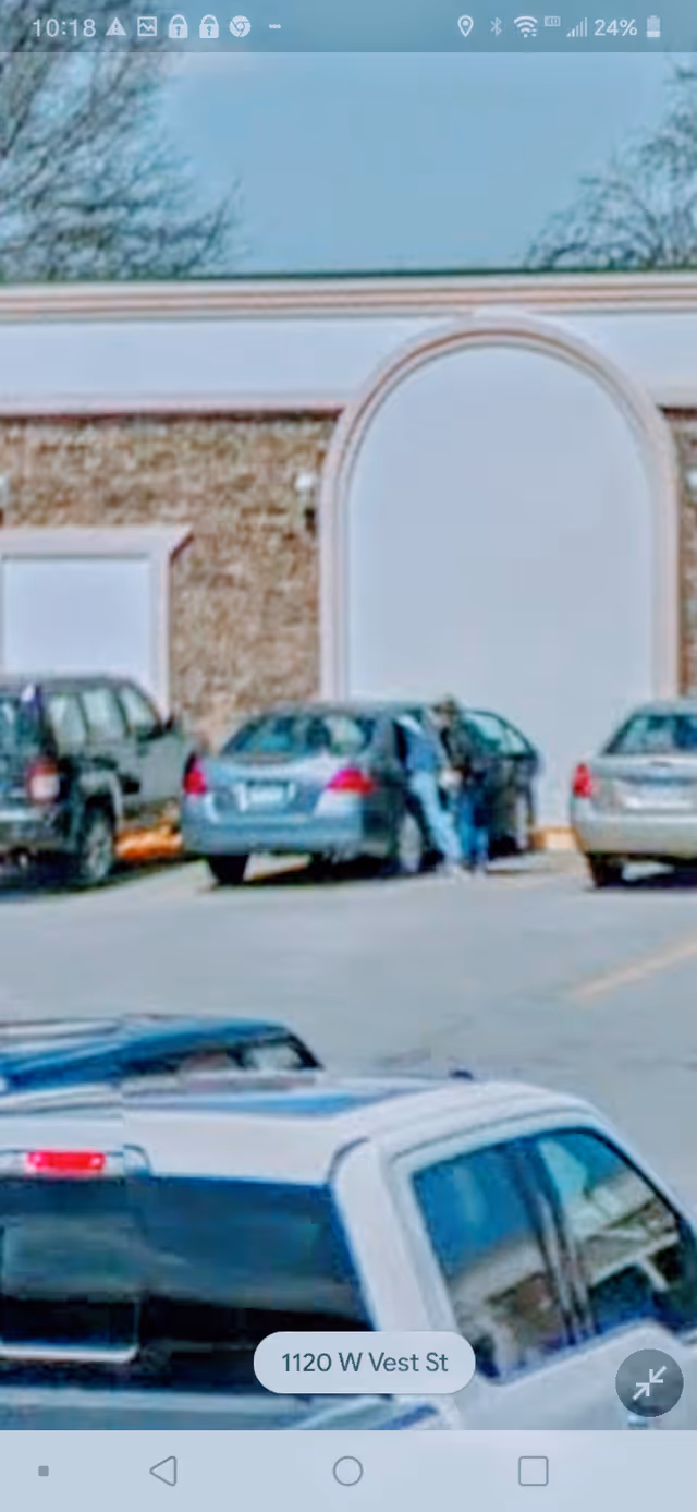 Exterior view of Vanderpools Residential Care with parked cars in a lot.