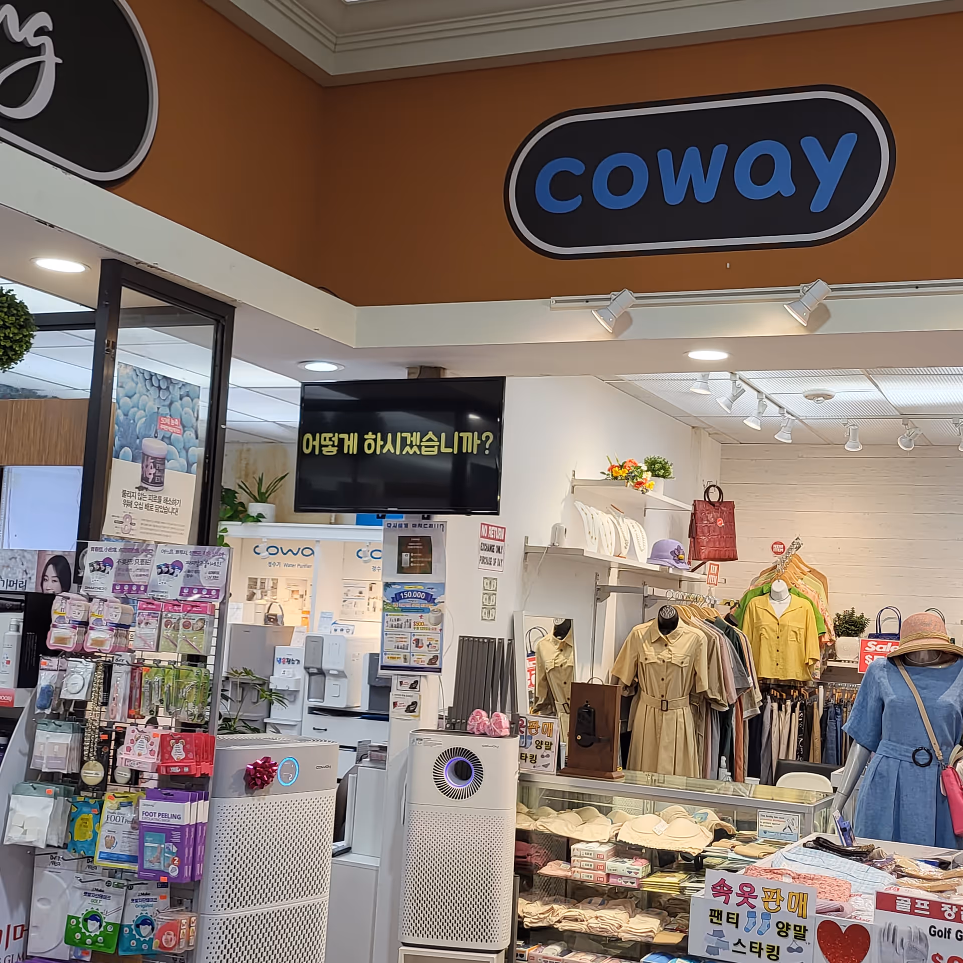 Indoor retail space with Coway sign, apparel displays, and product kiosks.