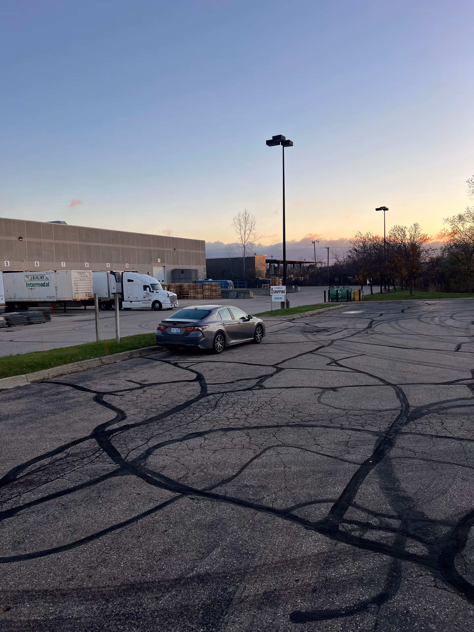 Exterior view of HoMedics facility with loading docks, trucks, and parking lot.
