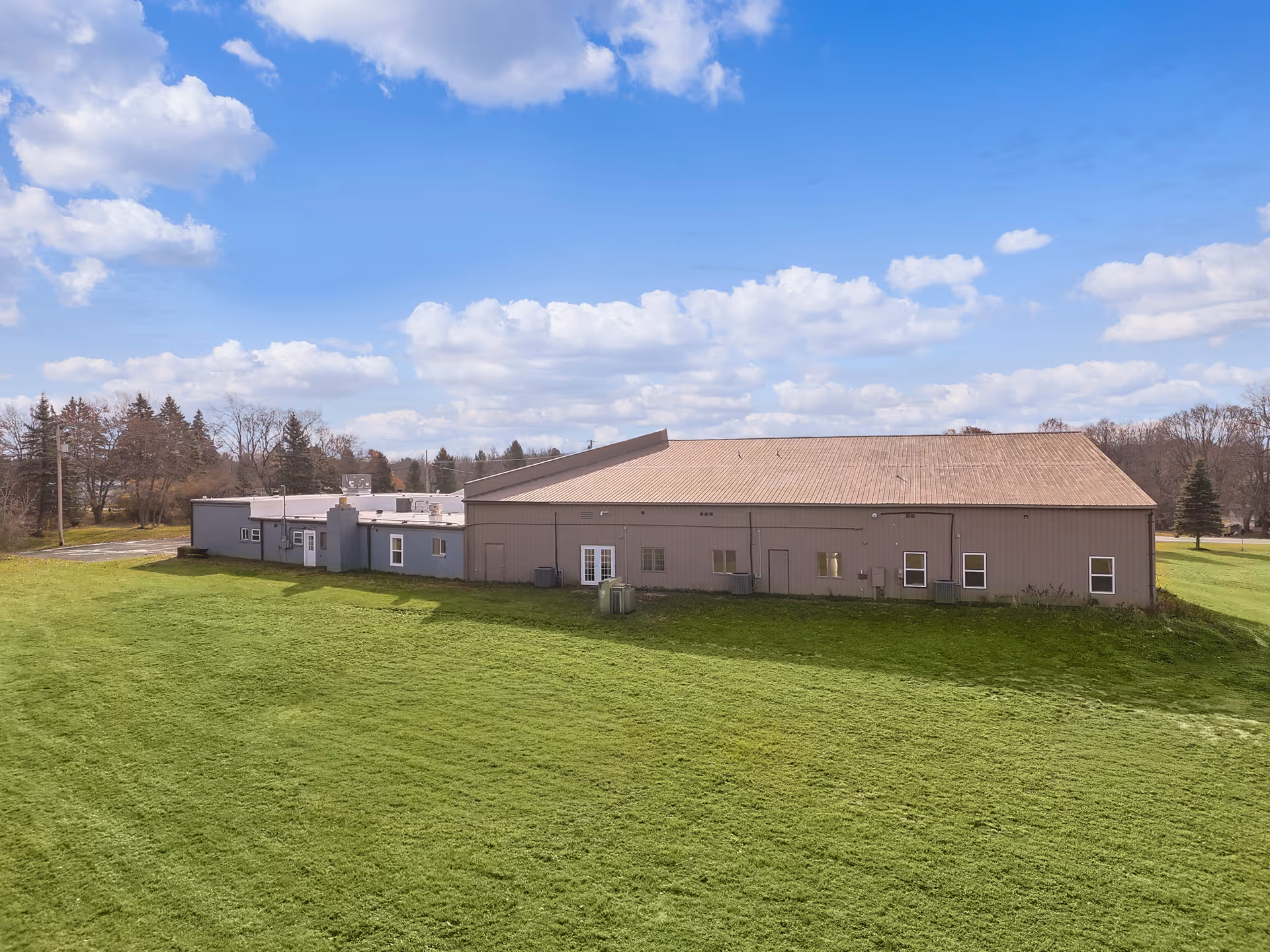 Exterior view of New Haven Assisted Living building on a grassy field under blue sky.