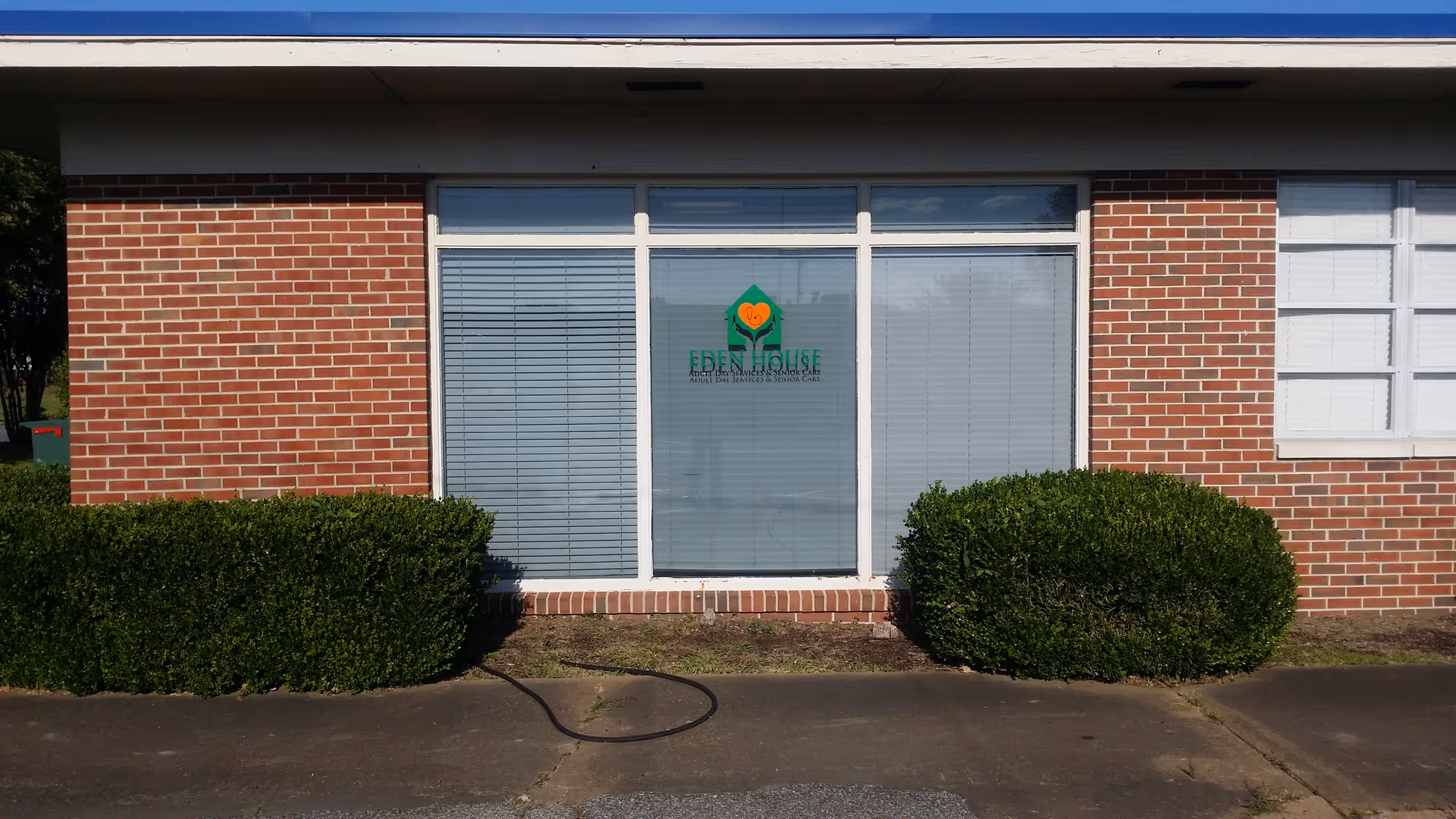 Front view of Eden House Home Care, LLC facility with brick exterior and glass door.