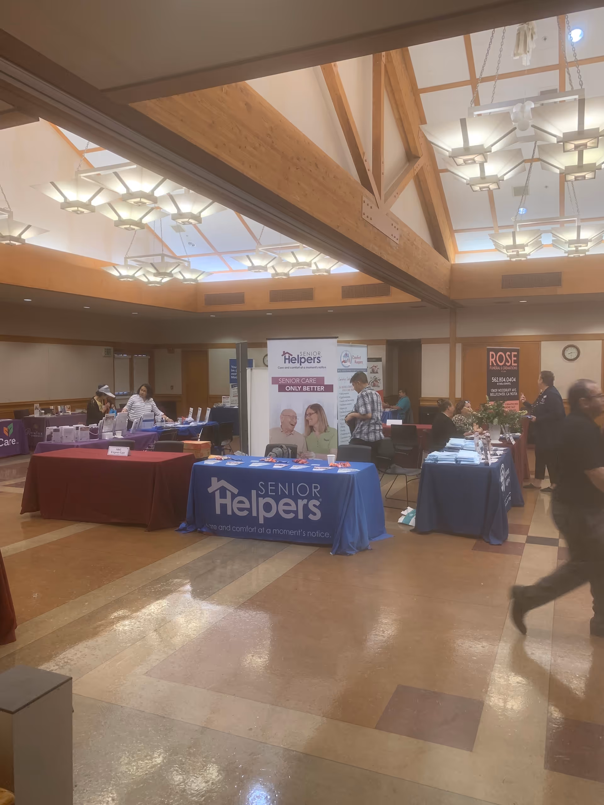 Indoor expo hall with vendor booths and a prominent Senior Helpers banner.