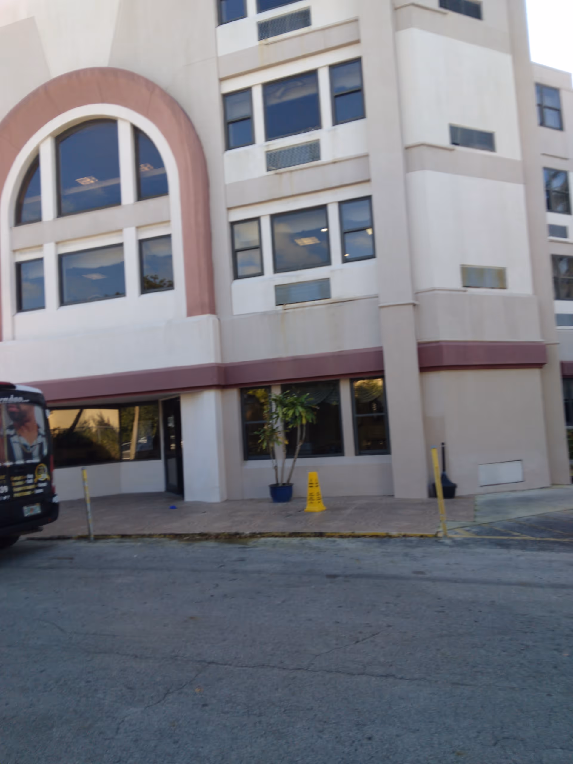Exterior view of a modern nursing center with a bus parked by the entrance.