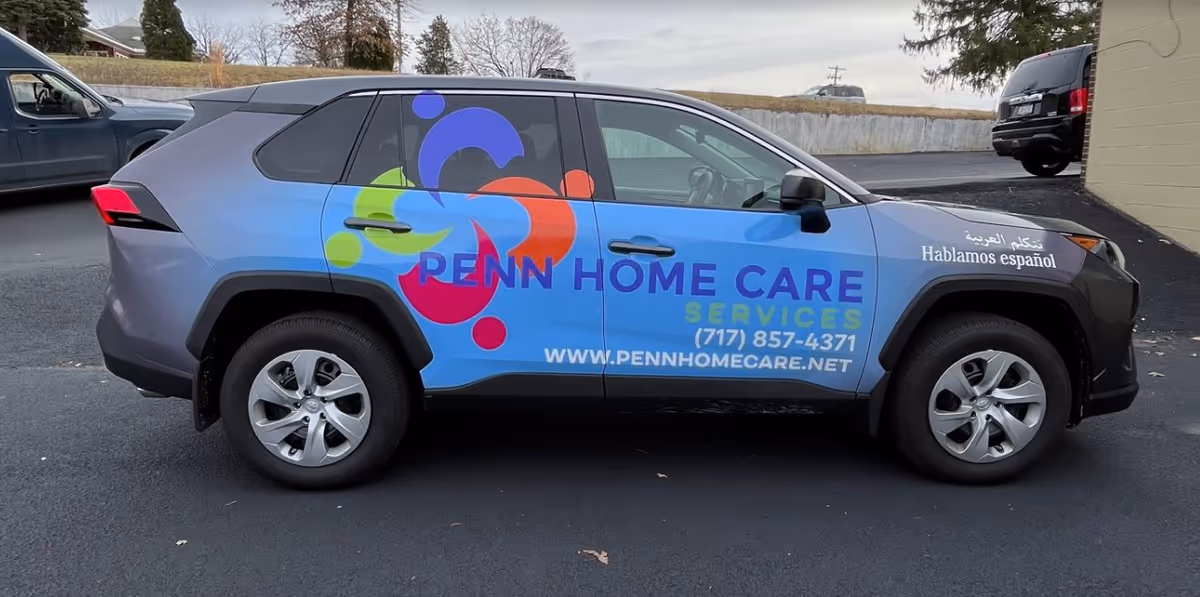Colorful Penn Home Care van parked in a lot, displaying logo and contact details.