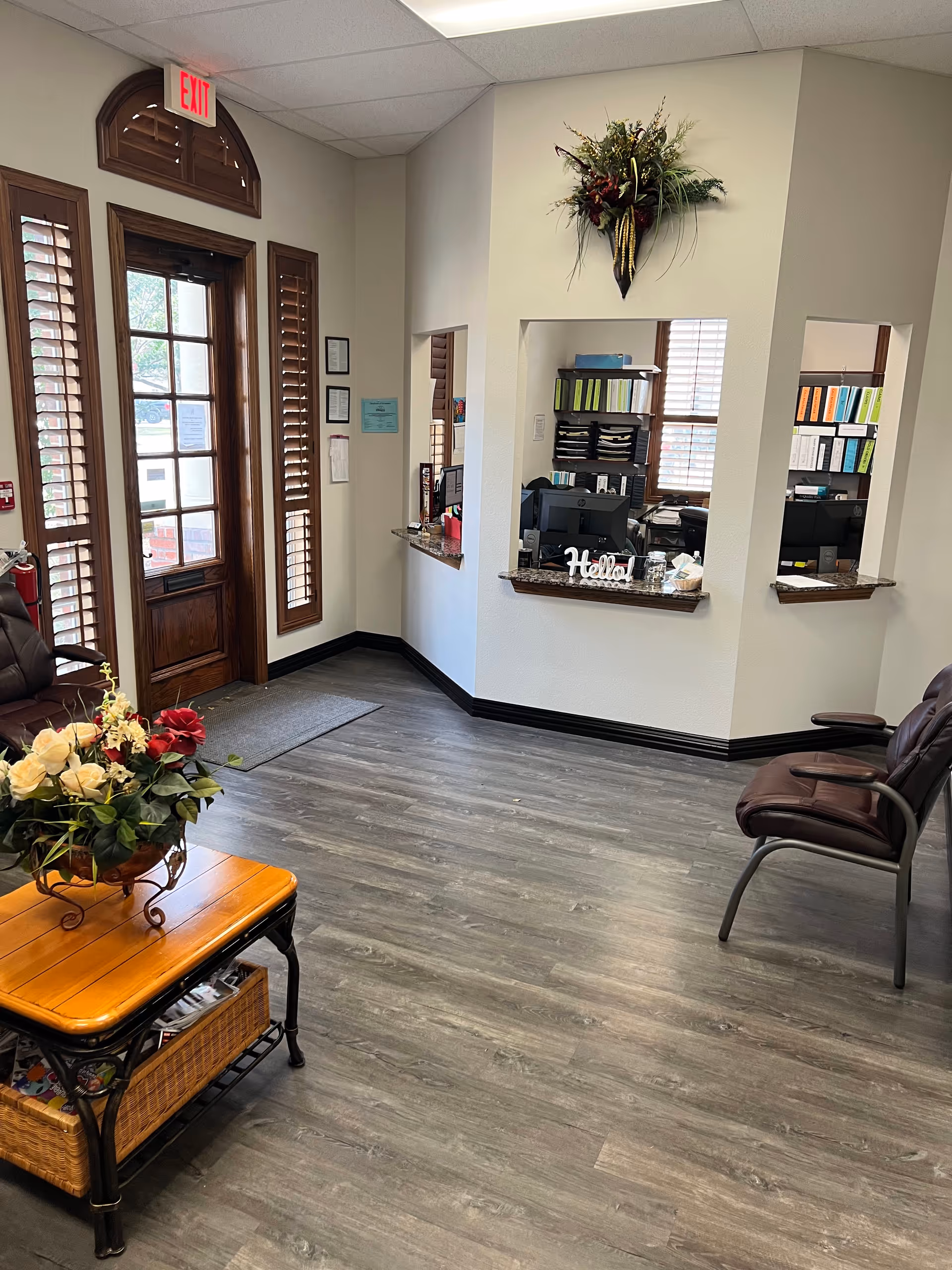 Senior living facility lobby with front desk, seating, and floral decor.