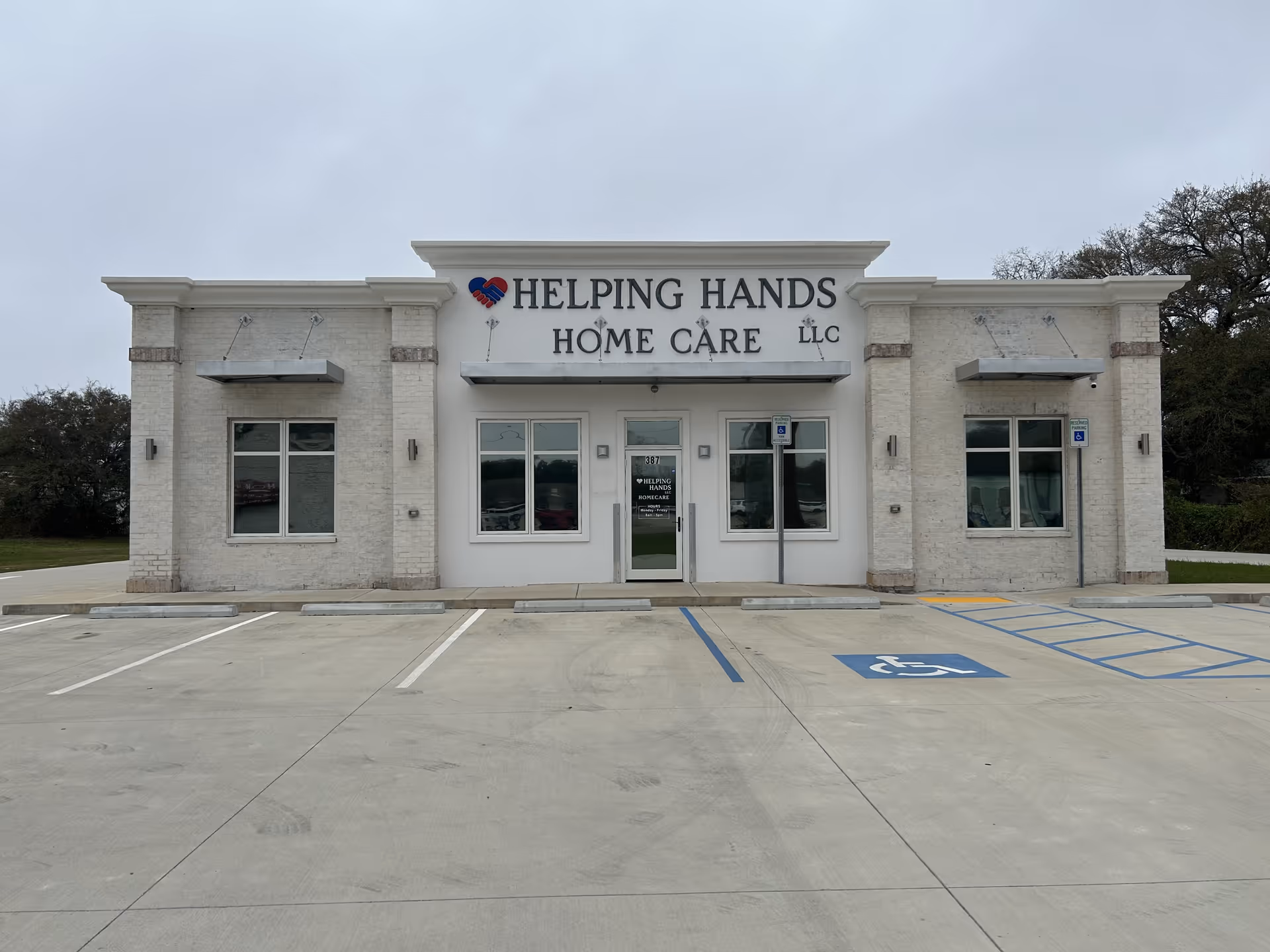 Front view of Helping Hands Home Care LLC building with parking lot.