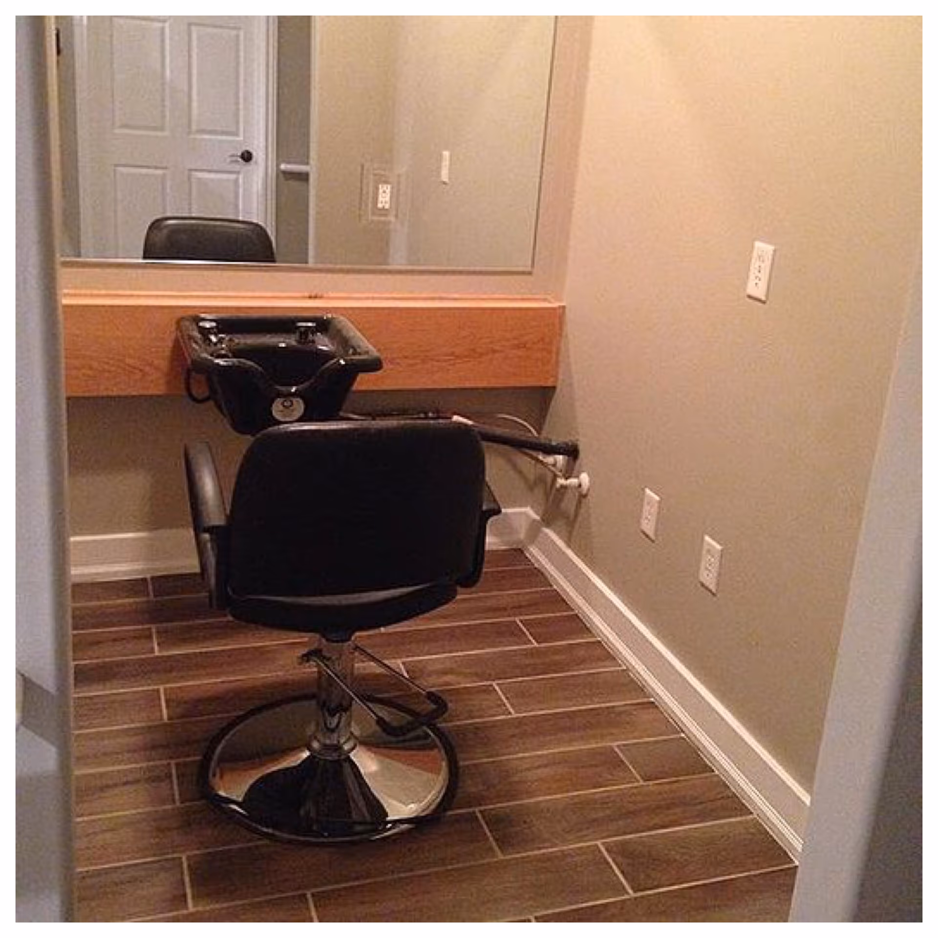 Hair salon chair and washbasin with mirror in a senior living facility.