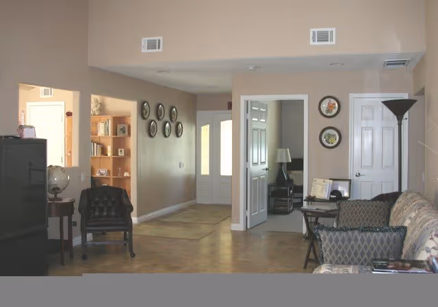 Interior common area with sofas, chairs, lamps, clocks, and doorway to other rooms.