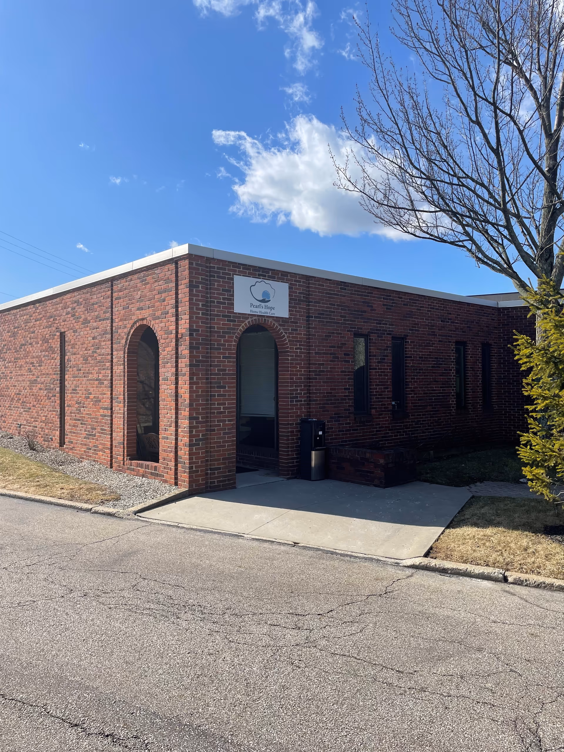 Brick building with arched entrance and Pearl's Hope Home Health Care sign.