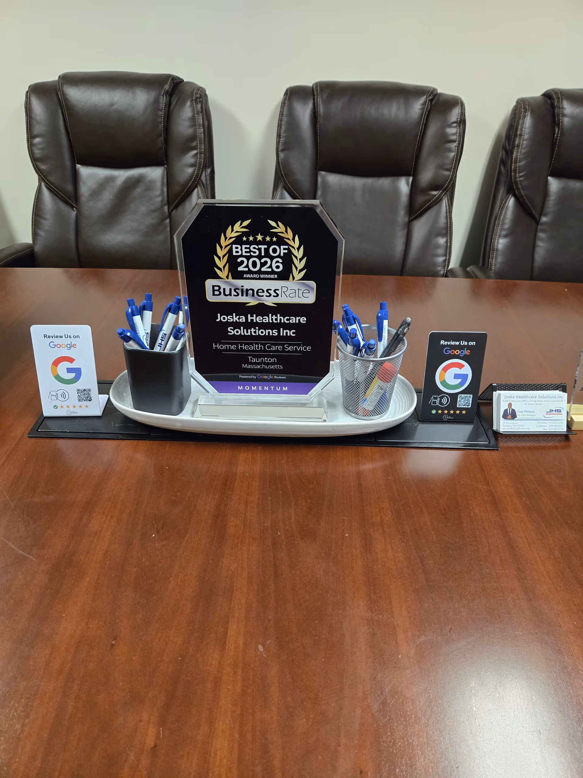 Conference table with an award plaque and pens in a meeting room.