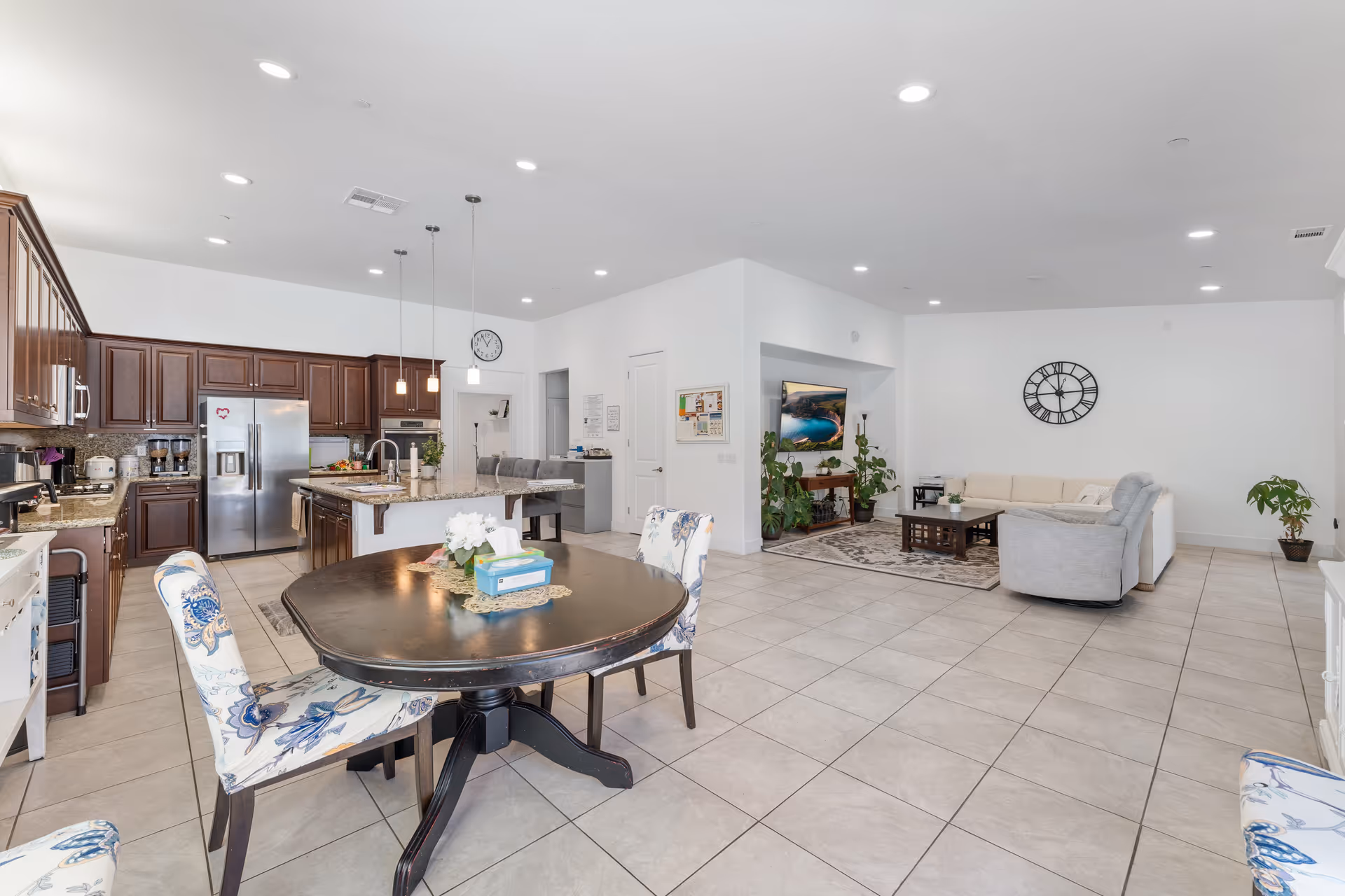 Open-concept common area with kitchen, round dining table, and living seating.