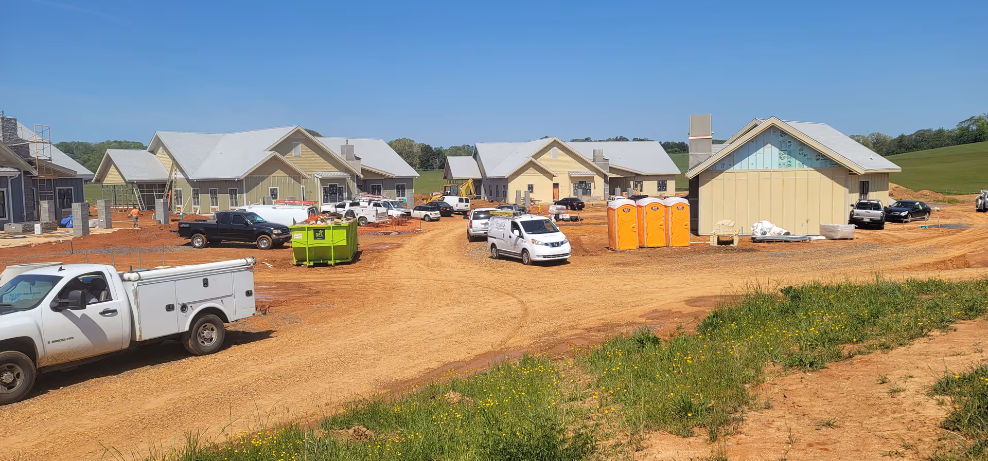 Construction site around Jefferson Park at White Pine shows building exteriors and portable toilets.