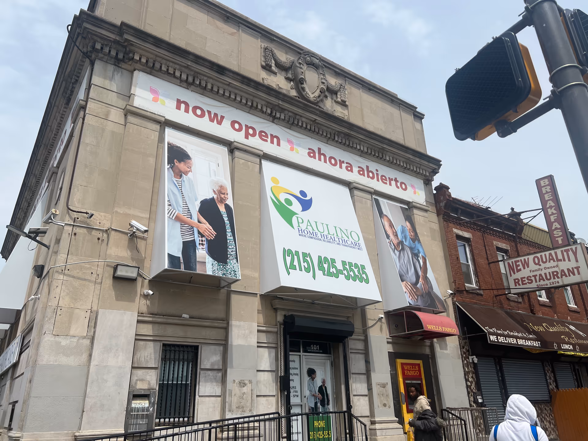 Facade of Paulino Home Healthcare building with banners announcing open and contact number.