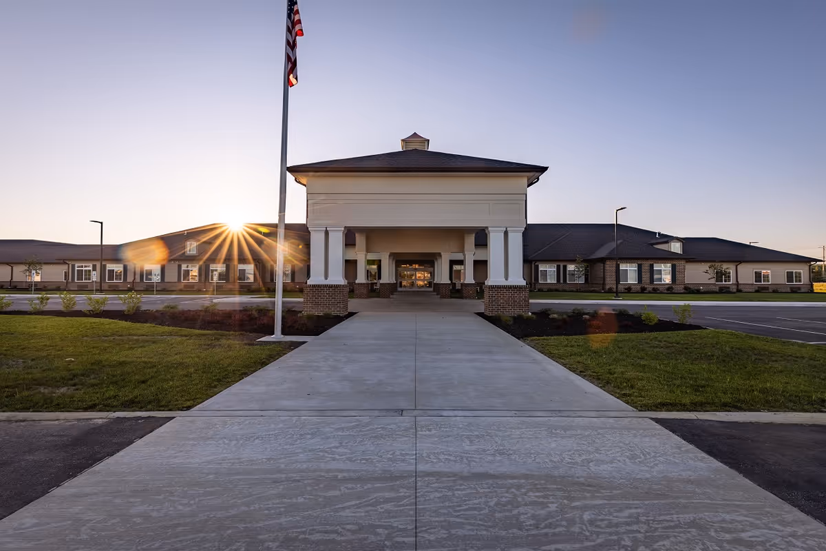 Exterior view of Homestead at Towne Center entrance with flagpole at sunrise.