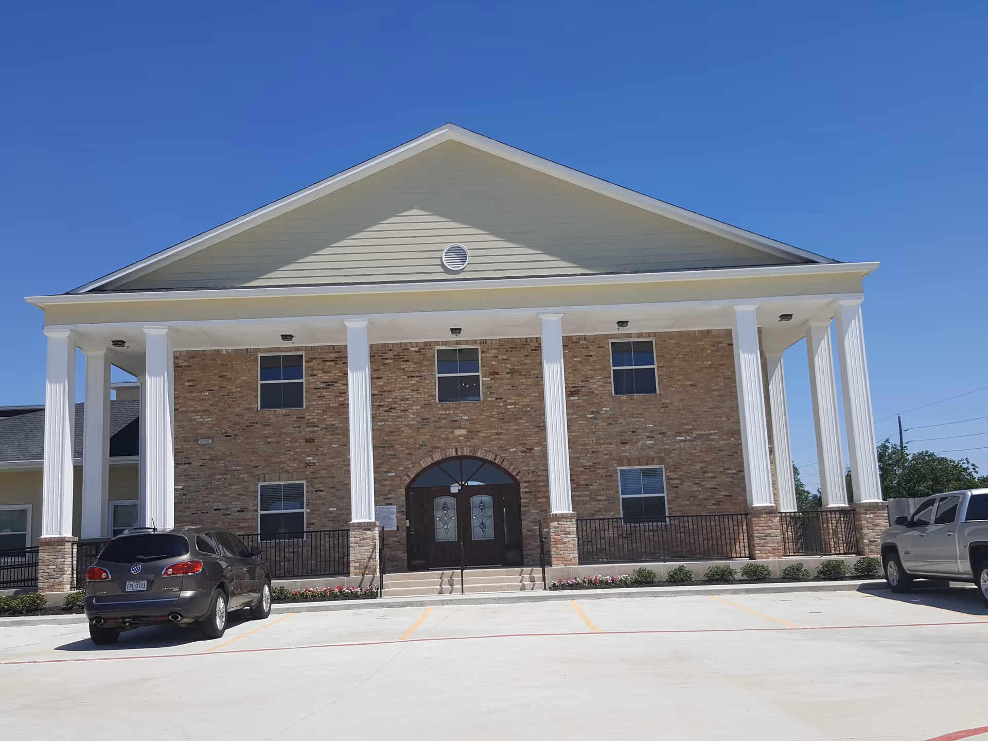 Apex Oaks senior living building with a white-columned front portico.