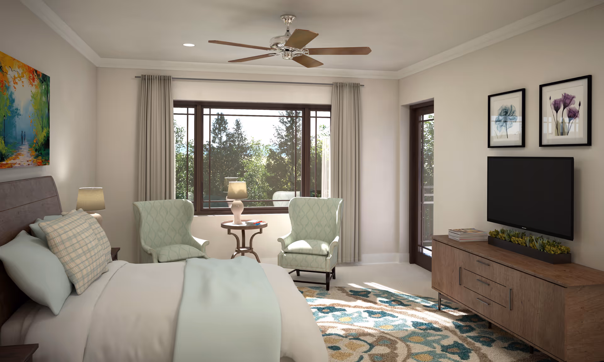 A bright and cozy bedroom with a large bed featuring light blue bedding and plaid pillows. Two light green armchairs are positioned near a window with beige curtains, accompanied by a small round wooden table with a lamp and books. A ceiling fan is mounted above, and a wooden dresser with a flat-screen TV and decorative plants is against the opposite wall. The room has light-colored walls, a colorful abstract painting above the bed, and two framed floral artworks above the TV. A patterned rug covers part of the carpeted floor.