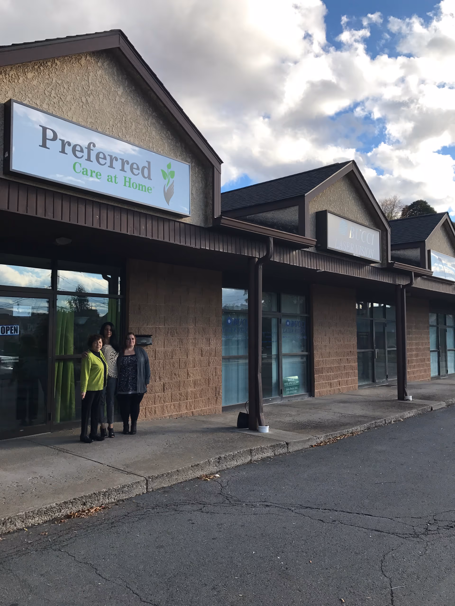 Exterior view of Preferred Care at Home storefront with four people standing outside.