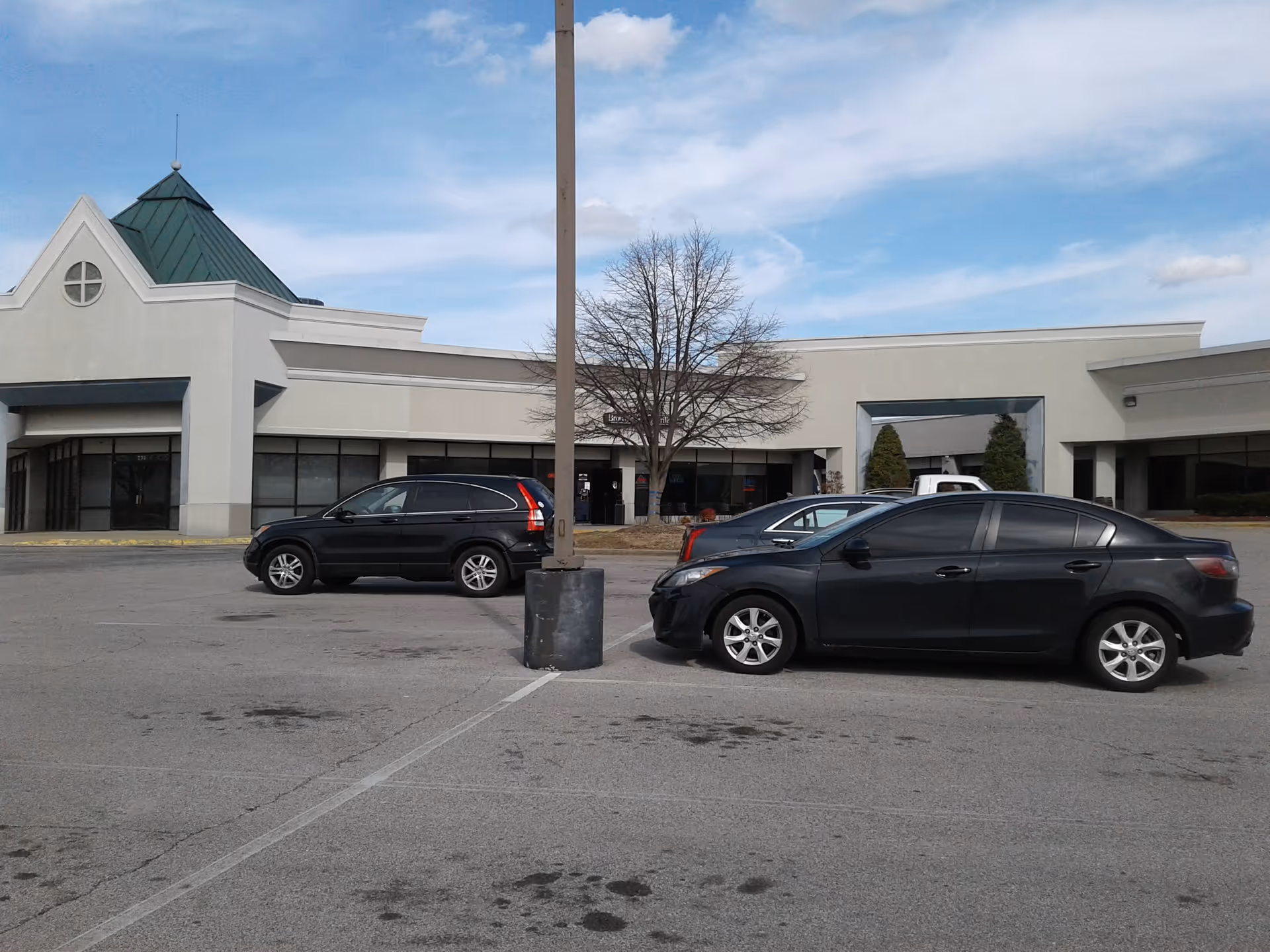Exterior view of a senior living facility storefront with parked cars in front