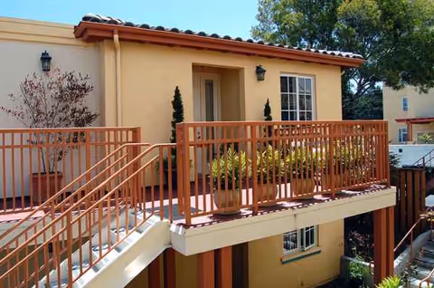 Exterior view of Forest Hill Post Acute with orange railing and potted plants.