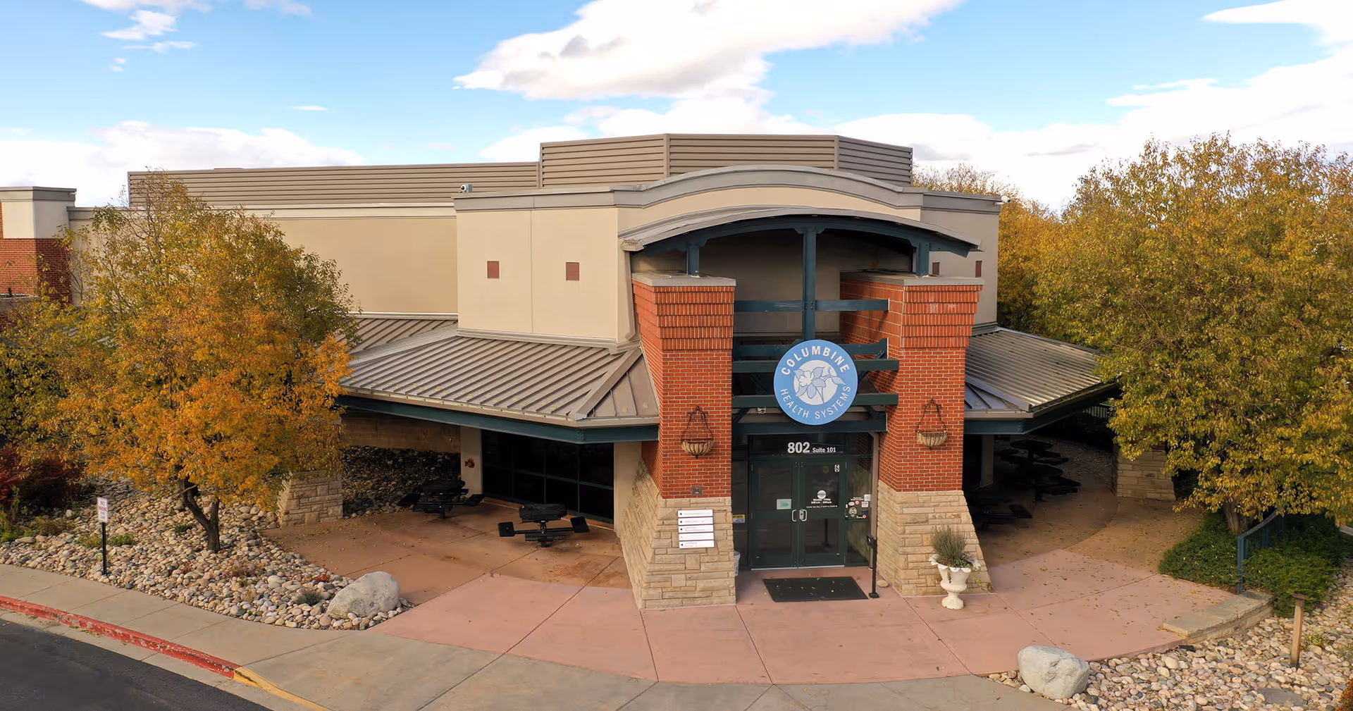 Exterior view of Columbine Health Systems entrance with brick pillars and signage.